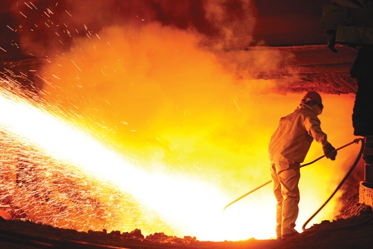 a scene from a steel mill featuring a large amount of sparks