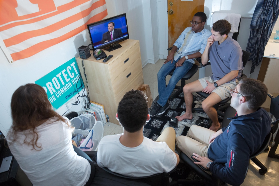 Students watch a Republican debate in a dorm