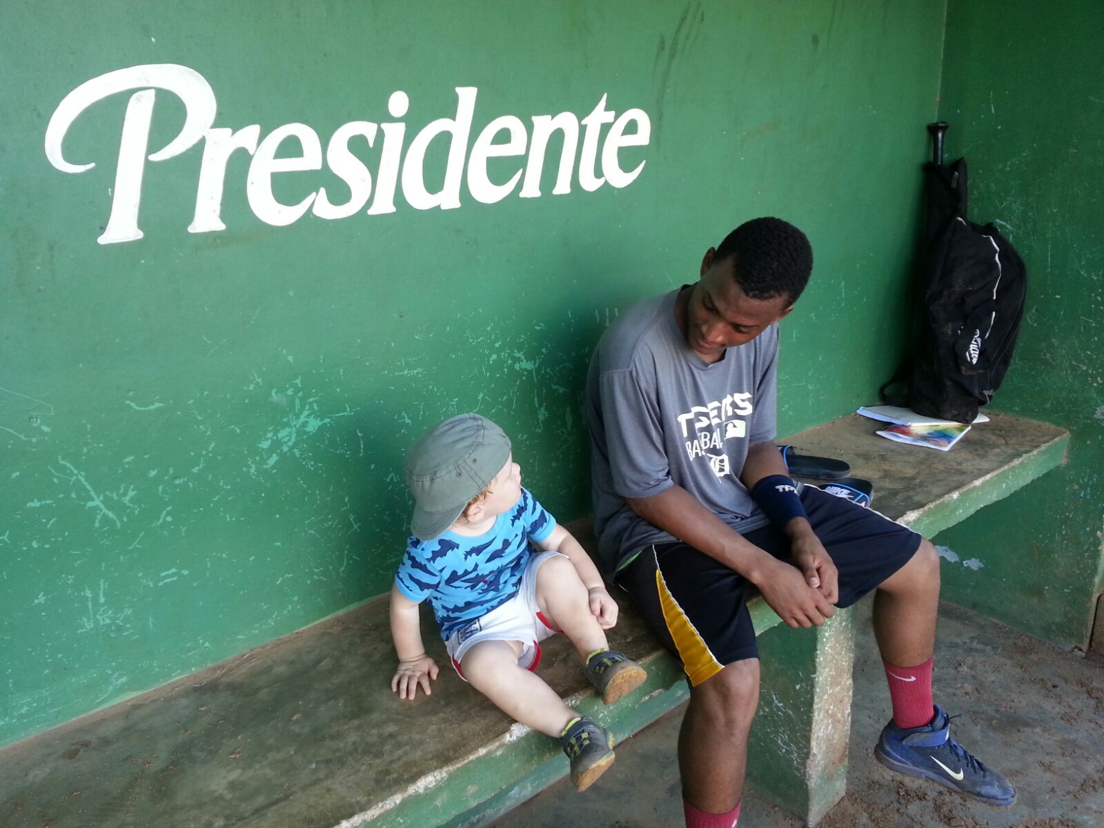 child and man sitting on a bench looking at each other
