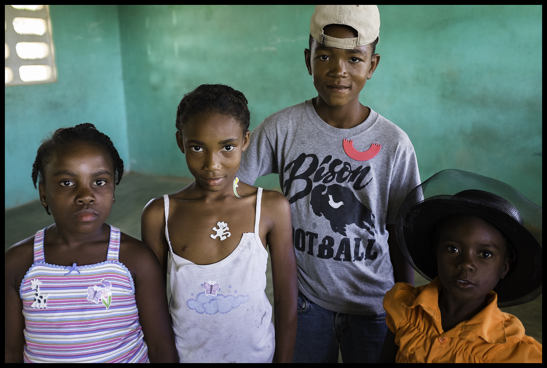 4 children, one wearing bison football shirt