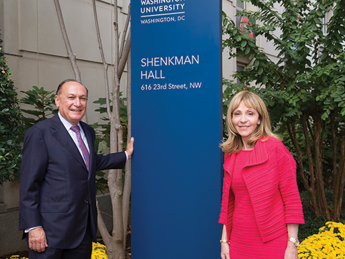 Alumnus Mark Shenkman and his wife, Rosalind, pose next to the Shenkman Hall street sign