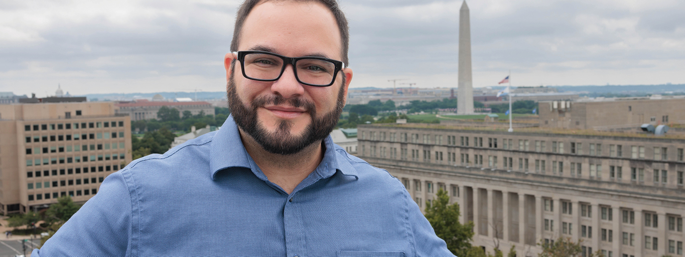 Alumnus David Gitter with the skyline of Washington D.C. in the background