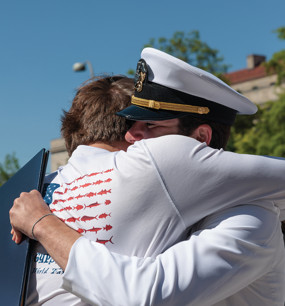 A father and son hug at the GW Naval Commissioning Ceremony
