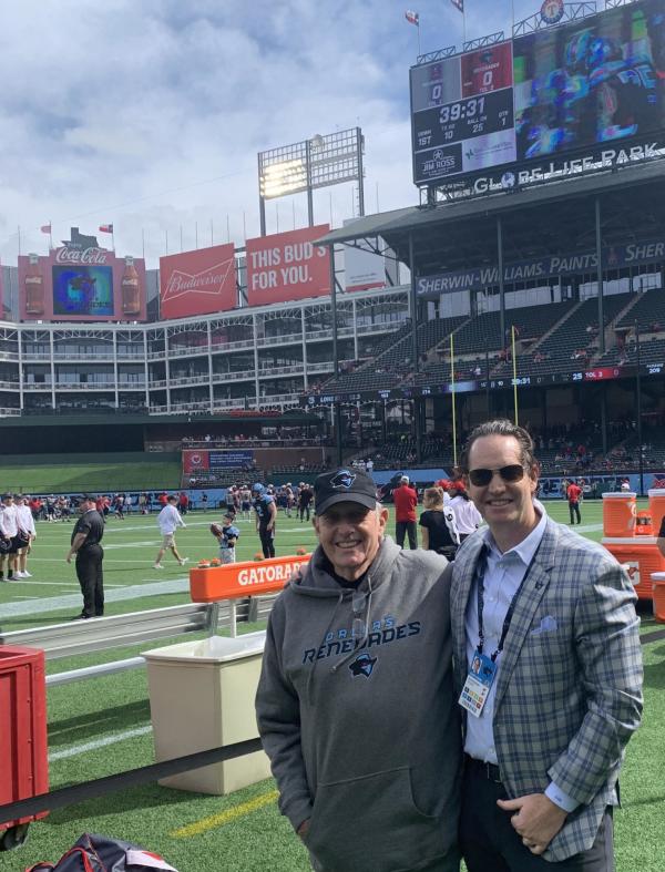 Grady Raskin (right) and his father Philip stand on the sidelines of a Dallas Renegades game.