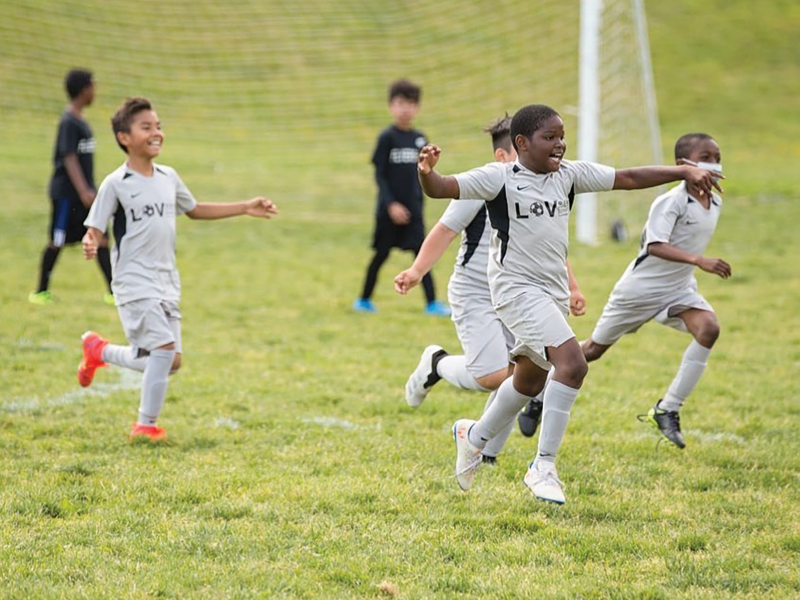 children running on soccer field