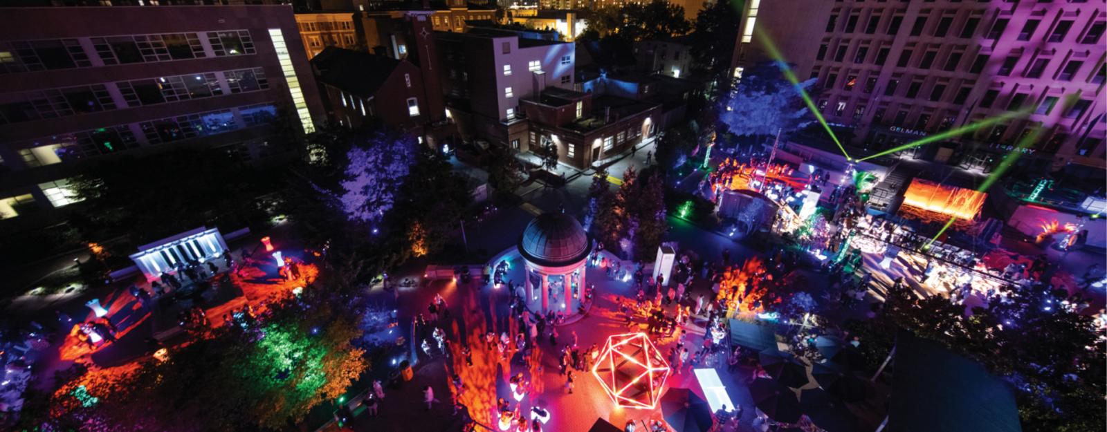 Kogan Plaza lit up for bicentennial bash. Students and other attendees can be seen walking through the plaza.