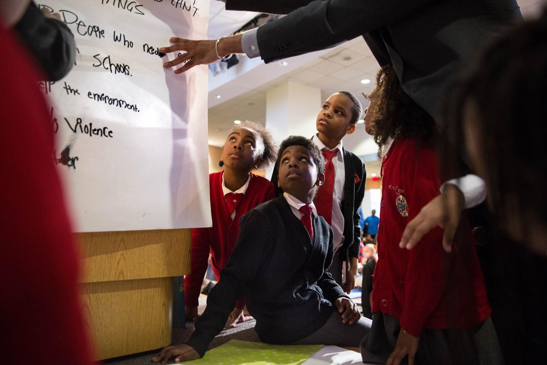 David J. Johns (top) reads to a roomful of kids before asking them to list what they would accomplish as president (bottom).